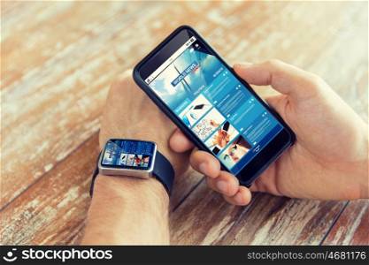 business, technology, media and people concept - close up of male hand holding smart phone and wearing watch with news web page
