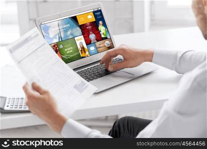 business, technology, multimedia and people concept - close up of businessman with internet news application on laptop computer screen working at office