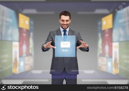 business, technology, multimedia and people concept - smiling businessman working with virtual email icon