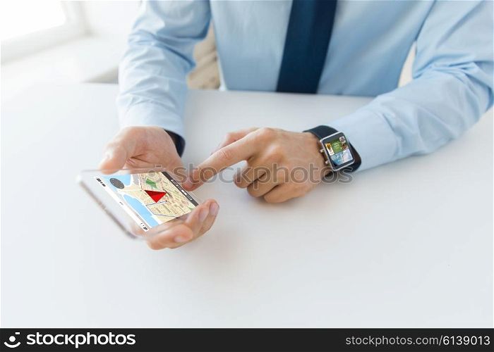 business, technology, navigation and people concept - close up of male hand holding and showing transparent smart phone and watch at office with gps navigator map on screen
