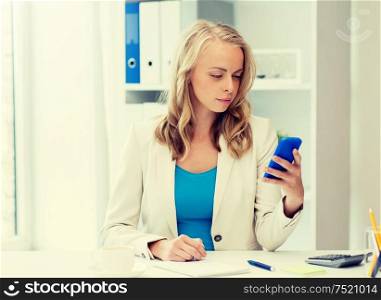 business, technology, people and communication concept - businesswoman texting on smartphone at office. businesswoman texting on smartphone at office