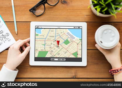 business, technology, people and navigation concept - close up of woman with gps navigator map on tablet pc computer screen and coffee on wooden table