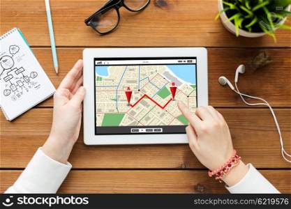 business, technology, people and navigation concept - close up of woman with gps navigator map on tablet pc computer screen on wooden table