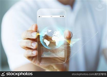 business, technology, science and people concept - close up of male hand holding and showing transparent smartphone earth globe projection
