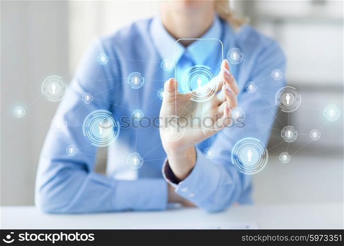 business, technology, social network and people concept - close up of woman hand holding and showing transparent smartphone with contact icons on screen at office