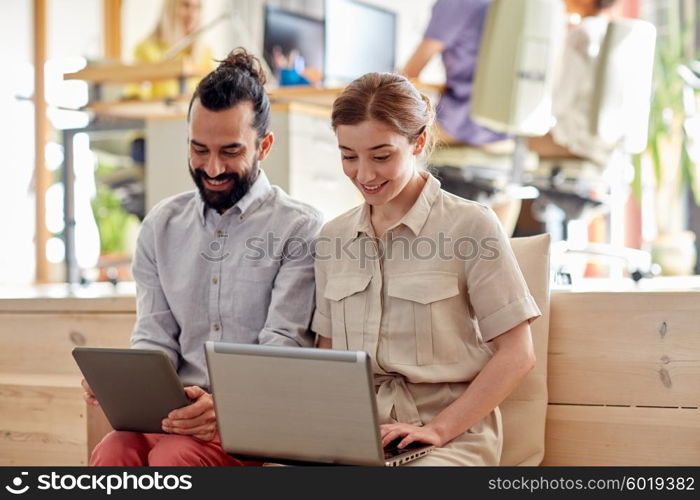 business, technology, startup and people concept - happy creative team with tablet pc and laptop computer in office