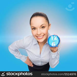 business, time and deadline concept - smiling businesswoman with blue clock