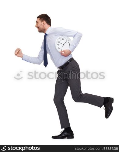 business, time and education concept - smiling young businessman with clock running