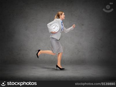 business, time and education concept - smiling young businesswoman with clock running