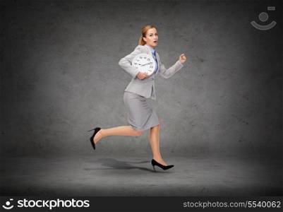 business, time and education concept - stressed young businesswoman with clock running