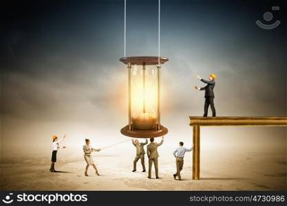 Business time. Conceptual image of business people looking at sandglass