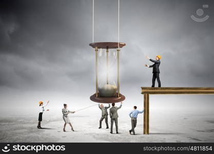 Business time. Conceptual image of business people looking at sandglass