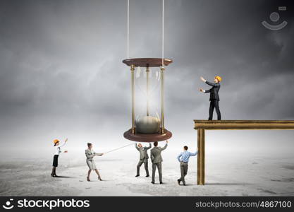 Business time. Conceptual image of business people looking at sandglass