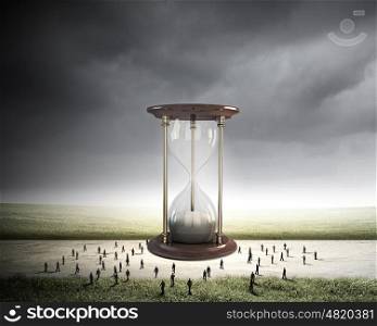 Business time. Conceptual image with sandglass and silhouettes of business people around