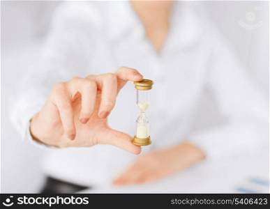 business, time management, deadline concept - woman hand with sandglass