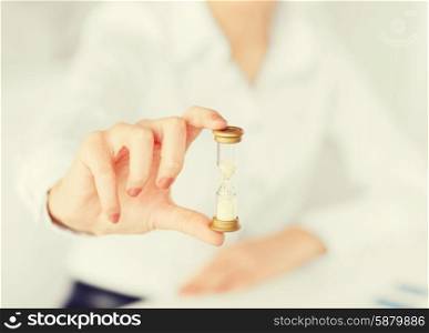 business, time management, deadline concept - woman hand with sandglass