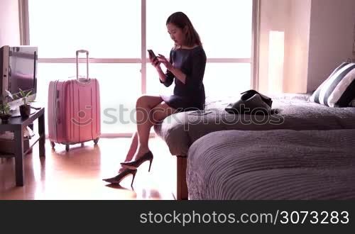 Business travel, people traveling, working in hotel room, happy Chinese female manager. Asian businesswoman, girl, woman at work, talking with smartphone, mobile phone, telephone. Modern life