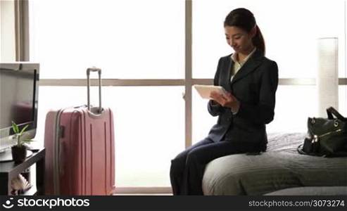 Business travel, people traveling, working in hotel room, Japanese female manager. Asian businesswoman, girl, woman at work, using ipad digital tablet, pc, computer for email, internet, social network