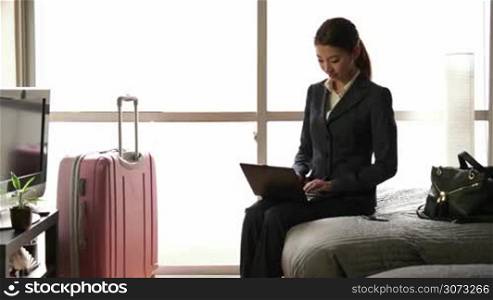 Business travel, people working in hotel room, happy Japanese manager. Asian businesswoman, busy girl talking on phone, woman at work, using pc, laptop, computer, notebook for internet, email