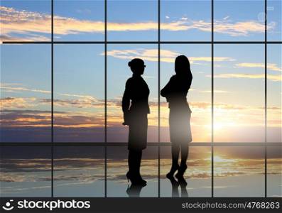 Business travel. Silhouette of businesswoman against panoramic office window