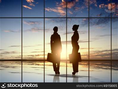Business travel. Silhouette of businesswoman against panoramic office window