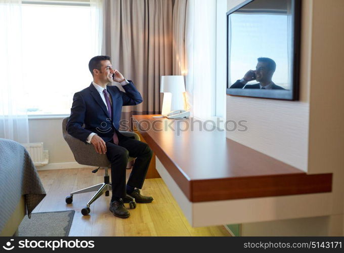 business trip, people and communication concept - businessman calling on smartphone at hotel room. businessman calling on smartphone at hotel room