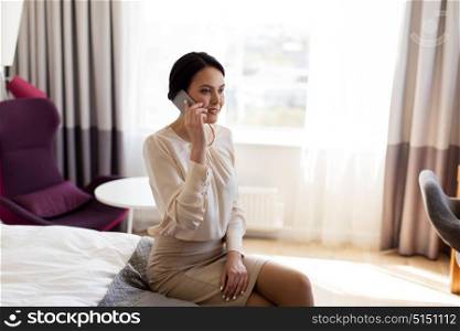 business trip, people and technology concept - businesswoman with smartphone at hotel room. businesswoman with smartphone at hotel room