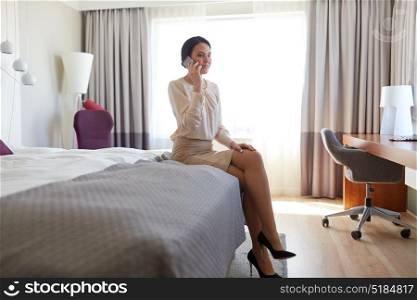 business trip, people and technology concept - happy businesswoman calling on smartphone at hotel room. happy businesswoman calling on smartphone at hotel