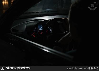 Business trip. Side view of confident and handsome young businessman in formal wear driving his car. Man driver in suit sitting behind the wheel of a car view from inside