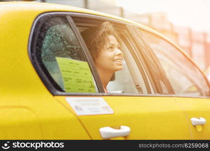 business trip, transportation and people concept - young smiling african american woman driving in taxi at city street