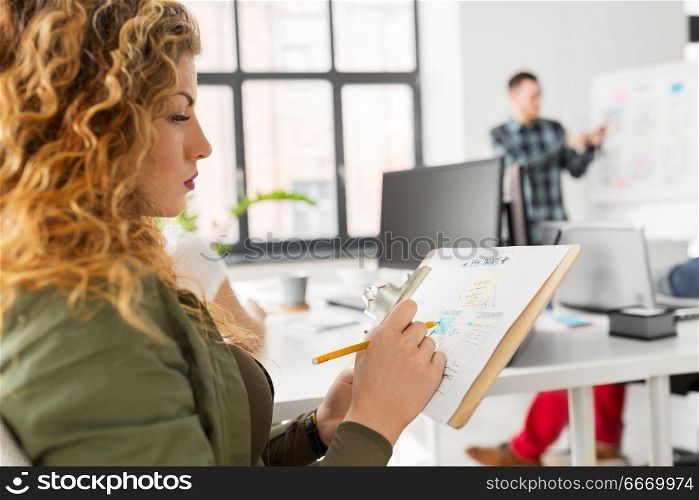 business, user interface design and people concept - creative woman with sketch on clipboard at office presentation. creative woman with sketch on clipboard at office. creative woman with sketch on clipboard at office