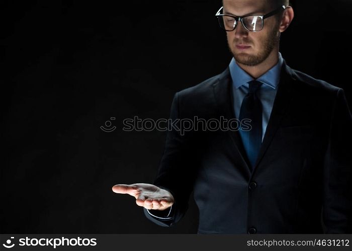 business, virtual reality, people and advertisement concept - close up of businessman in suit holding something imaginary on palm of his hand