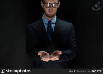 business, virtual reality, people and advertisement concept - close up of businessman in suit holding something imaginary on palms of his hands