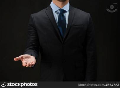 business, virtual reality, people, technology, cyberspace and office concept - close up of businessman in suit holding something imaginary on palm of his hand