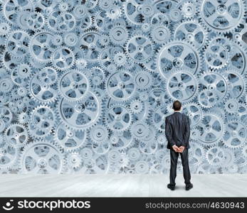 Business vision. Back view of confident businessman looking at city with items flying in air