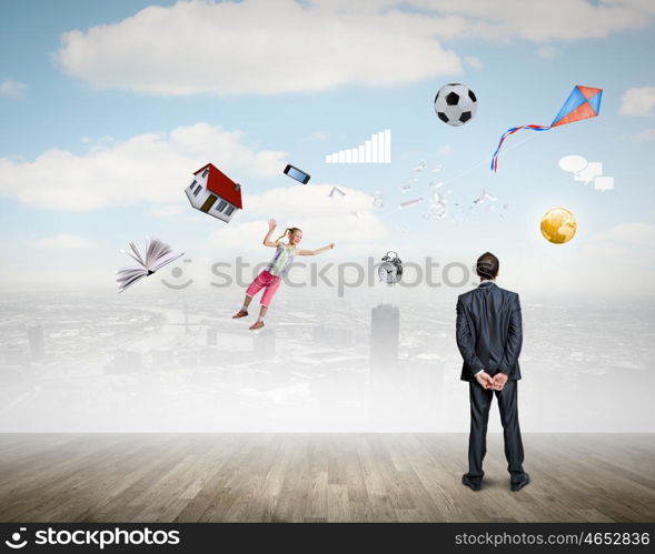 Business vision. Back view of confident businessman looking at city with items flying in air