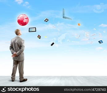 Business vision. Back view of confident businessman looking at items flying in air