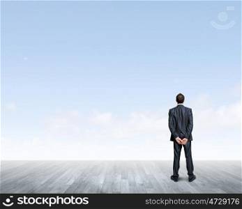 Business vision. Back view of confident businessman looking into the distance