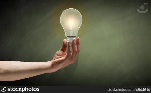 Business vision. Close up of hand holding glowing light bulb
