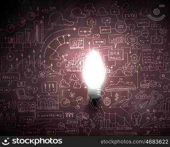 Business vision. Glowing light bulb with sketches at background