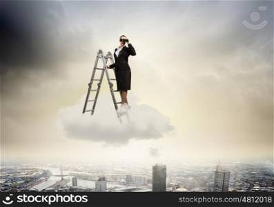 Business vision. Image of businesswoman standing on ladder and looking in binoculars
