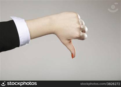 Business woman&#39;s thumb down hand sign gray background