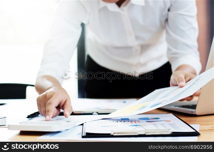 Business woman analysis investment perform data document and calculating a valuation number