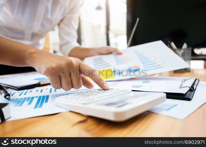 Business woman analysis investment perform data document and calculating a valuation number