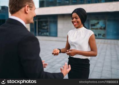 Business woman and businessman, outdoors meeting of partners, partnership negotiations. Successful businesspeople