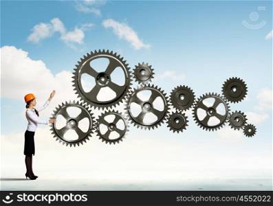 Business woman and mechanism elements. Businesswoman with cog wheel elements. Construction concept