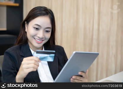 business woman asian using tablet and credit card shopping online