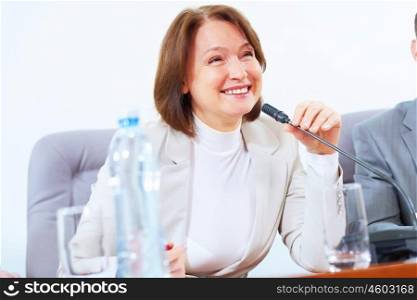 Business woman at meeting. Image of businesswoman at business meeting speakig in microphone