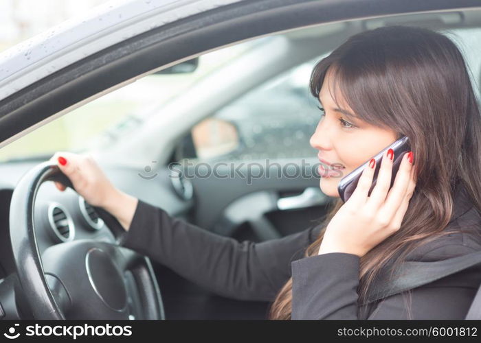 Business woman at the phone while driving