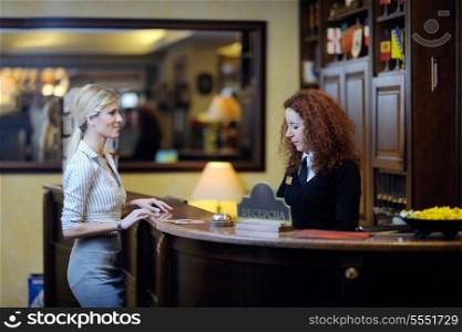 business woman at the reception of a hotel checking in